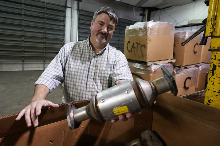Troy Webber, owner of Chesterfield Auto Parts, holds a used catalytic converter that was removed from one of the cars at his salvage yard Friday Dec. 17, 2021, in Richmond, Va. Thefts of the emission control devices have jumped over the last two years as prices for the precious metals they contain have skyrocketed.