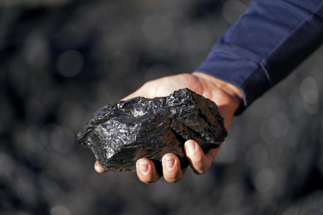 Sean Hovorka, production superintendent Trapper Mining, holds coal from the Trapper Mine on Thursday, Nov. 18, 2021, in Craig, Colo. Hovorka, also recently elected member of the town's city council, sees a future in mining because of renewables.