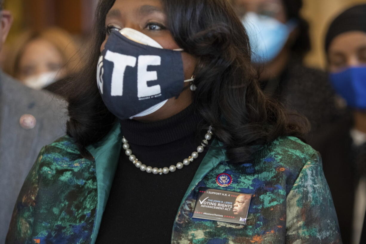 Rep. Terri Sewell, D-Ala., wears a pin honoring John Lewis while standing alongside other members of the Congressional Black Caucus speaking in front of the Senate chambers about their support of voting rights legislation at the Capitol in Washington, Wednesday, Jan. 19, 2022.