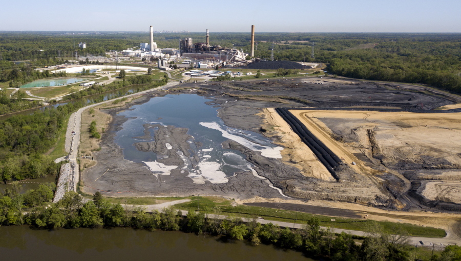 FILE - In this May 1, 2018, file photo, the Richmond, Va., city skyline is seen in the horizon behind the coal ash ponds along the James River near Dominion Energy's Chesterfield Power Station in Chester, Va. In the first first major action to address toxic wastewater from coal-burning power plants, the Environmental Protection Agency is denying requests by three Midwest power plants to extend operations of leaking or otherwise dangerous coal ash storage ponds.