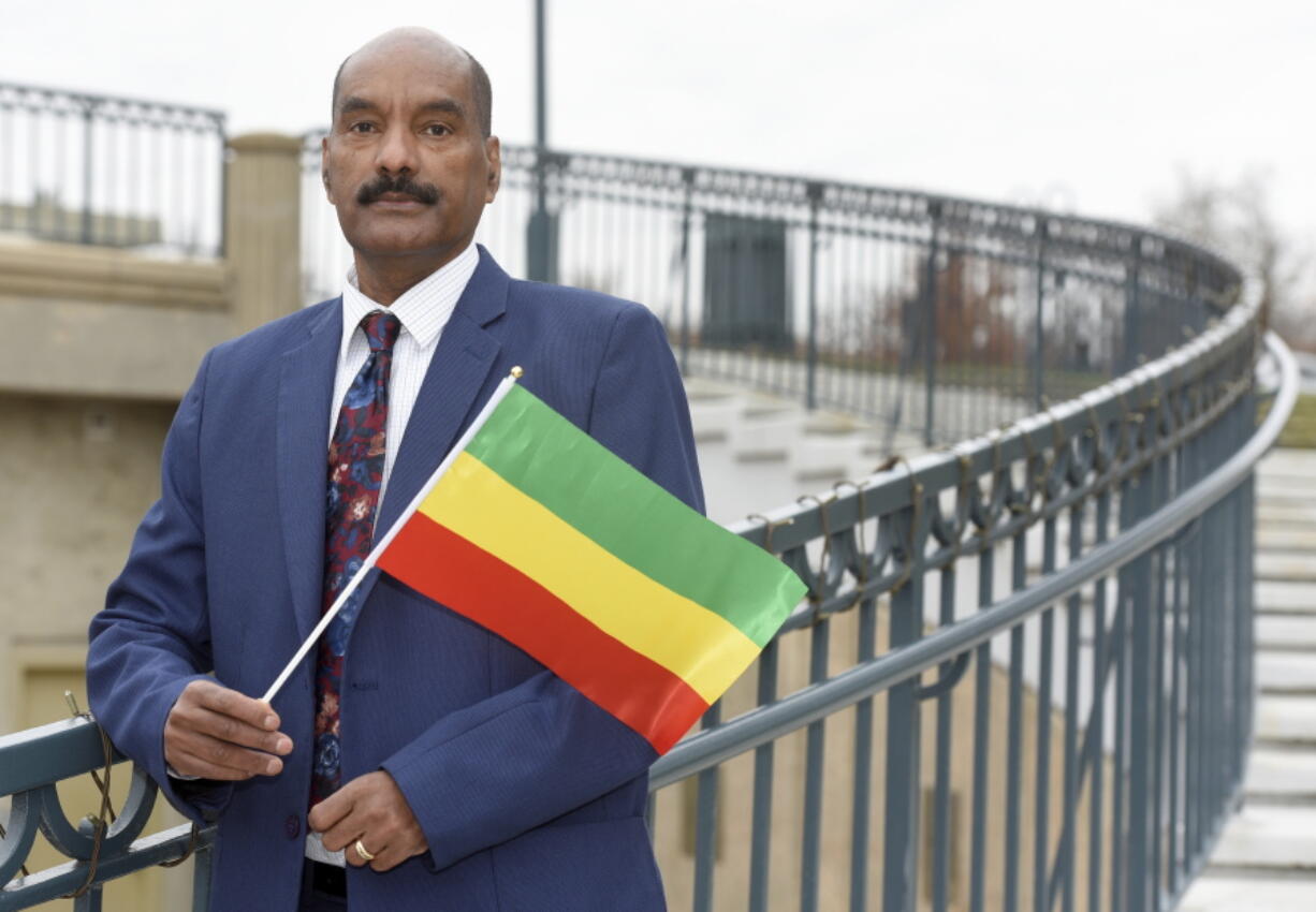 Negasi Beyene, who grew up in Mekele, the capital city of the Ethiopia's Tigray Region, holds a traditional Ethiopian flag Saturday, Dec. 18, 2021 in Columbia, Md. Beyene, who works as a biostatistician near Washington, identifies as a human rights activist for Ethiopian unity.