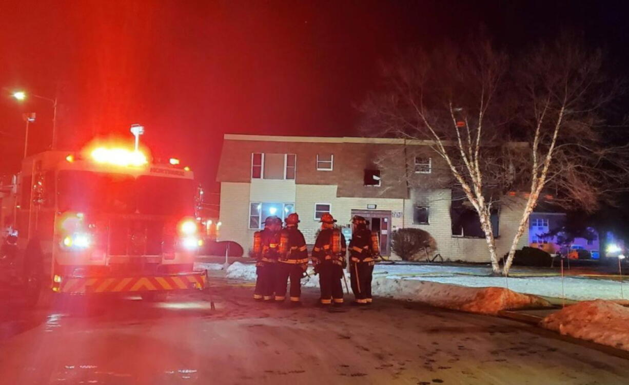 Kenosha firefighters confer at the scene of a deadly blaze Monday, Jan. 18, 2022 in the Saxony Manor apartment complex in Kenosha, Wis.