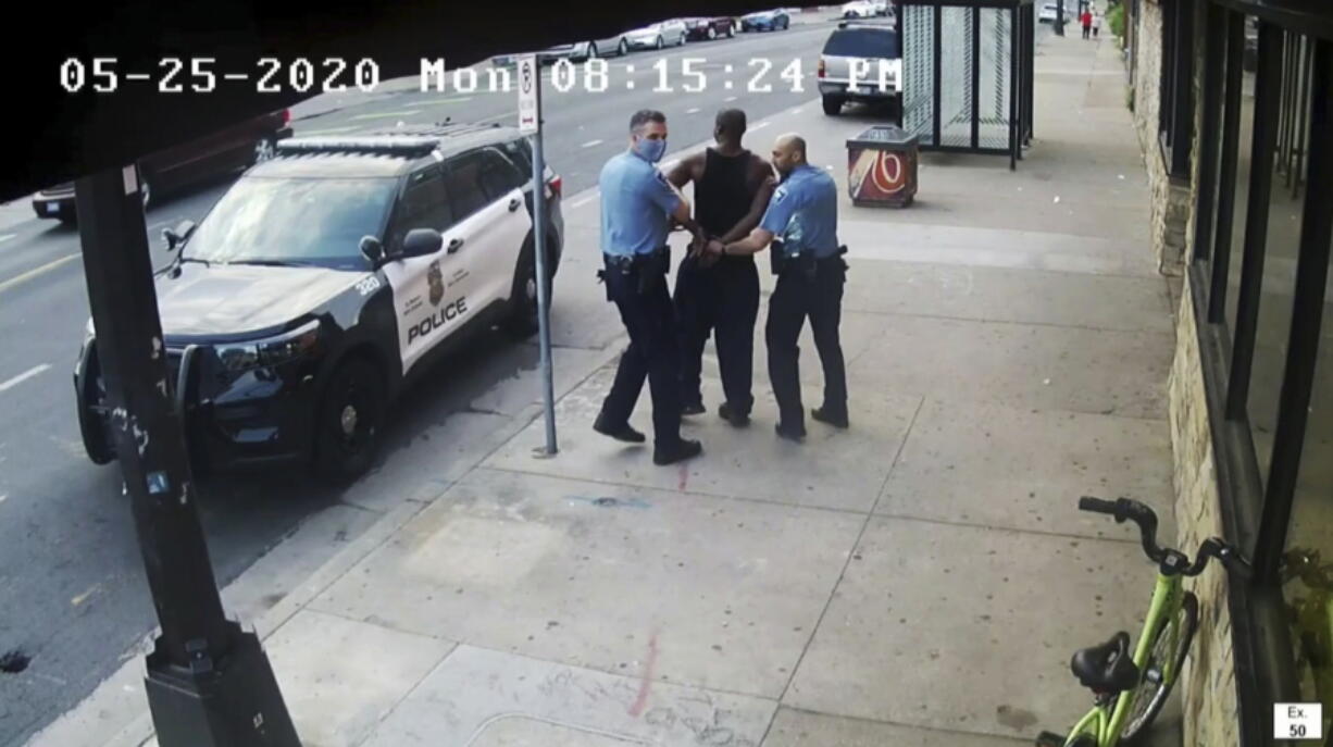 FILE - This image from video shows Minneapolis police Officers Thomas Lane, left and J. Alexander Kueng, right, escorting George Floyd, center, to a police vehicle outside Cup Foods in Minneapolis, on May 25, 2020. Three former Minneapolis officers headed to trial this week on federal civil rights charges in the death of George Floyd aren't as familiar to most people as Derek Chauvin, a fellow officer who was convicted of murder last spring.