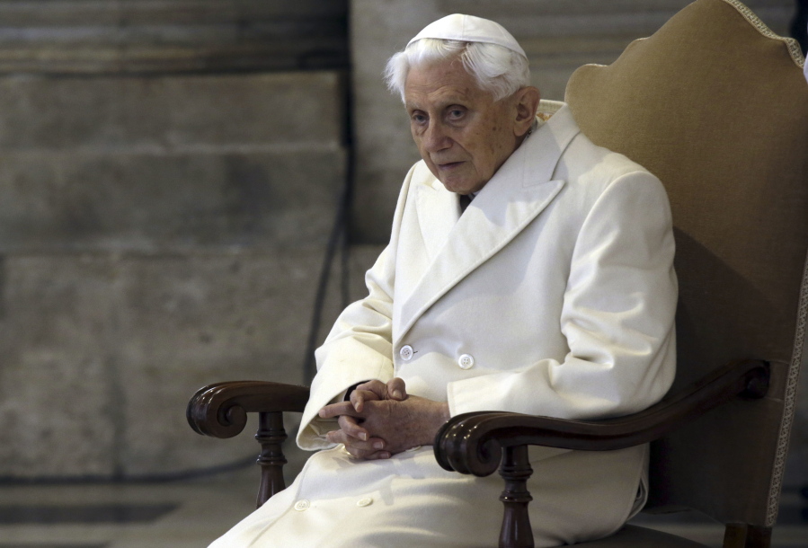FILE - Pope Emeritus Benedict XVI sits in St. Peter's Basilica as he attends the ceremony marking the start of the Holy Year, at the Vatican, Dec. 8, 2015. A long-awaited report on the church's handling of cases of sexual abuse by clergy and others in Germany's Munich archdiocese and which was once led by retired Pope Benedict XVI from 1977 until 1982, is being released on Thursday Jan. 20, 2022.