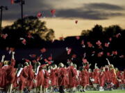 FILE - Red mortarboards fly into the evening sky at Heritage High School's commencement ceremony Friday, July 24, 2020, in Maryville Tenn.  High school graduation rates dipped in at least 20 states after the first full school year disrupted by the pandemic, according to a new analysis by Chalkbeat.