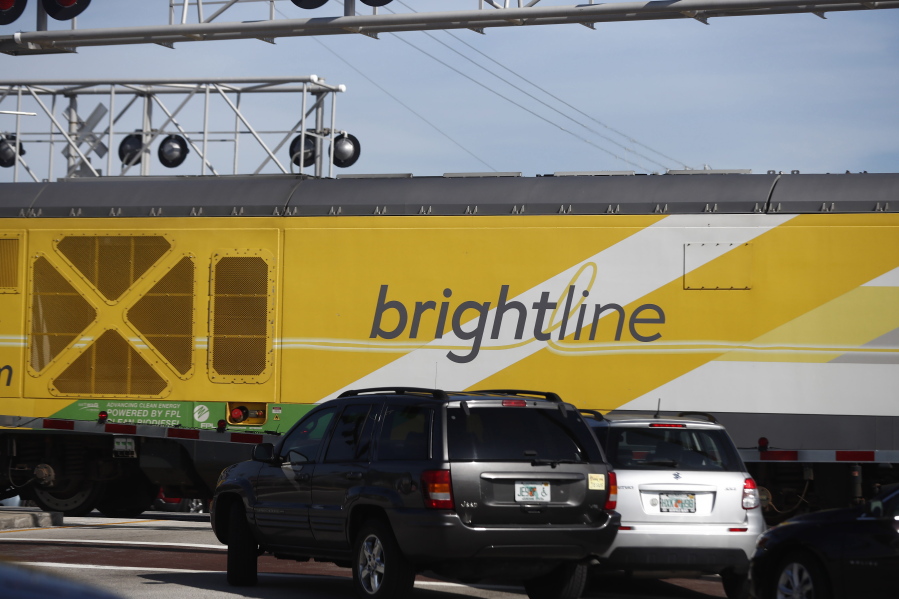 FILE - Vehicles wait for a Brightline passenger train to pass on Wednesday, Nov. 27, 2019, in Oakland Park, Fla.  A Brightline higher-speed train fatally struck a pedestrian who walked into its path Tuesday, Jan. 4, 2022, the fifth death involving the railroad since it recently resumed operations after being shutdown because of the pandemic. Boynton Beach police said that the pedestrian was struck shortly before 8 a.m. No further details were immediately available.