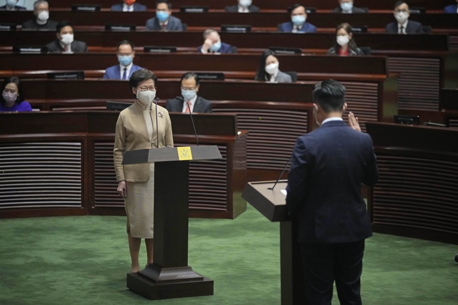 Newly elected pro-Beijing lawmaker Vincent Cheng Wing-shun, right, takes his oath in front of Chief Executive Carrie Lam during the oath-taking ceremony of the legislative council in Hong Kong, Monday, Jan. 3, 2022.