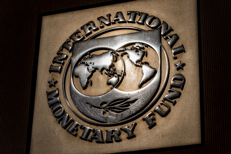 FILE - The logo of the International Monetary Fund is visible on their building, Monday, April 5, 2021, in Washington. The International Monetary Fund is downgrading its forecast for the world economy this year, Tuesday, Jan. 25, 2022. It cites as the cause for the lowered growth expectation the spread of COVID-19's omicron variant, higher energy prices, an uptick in inflation and financial strains in China.