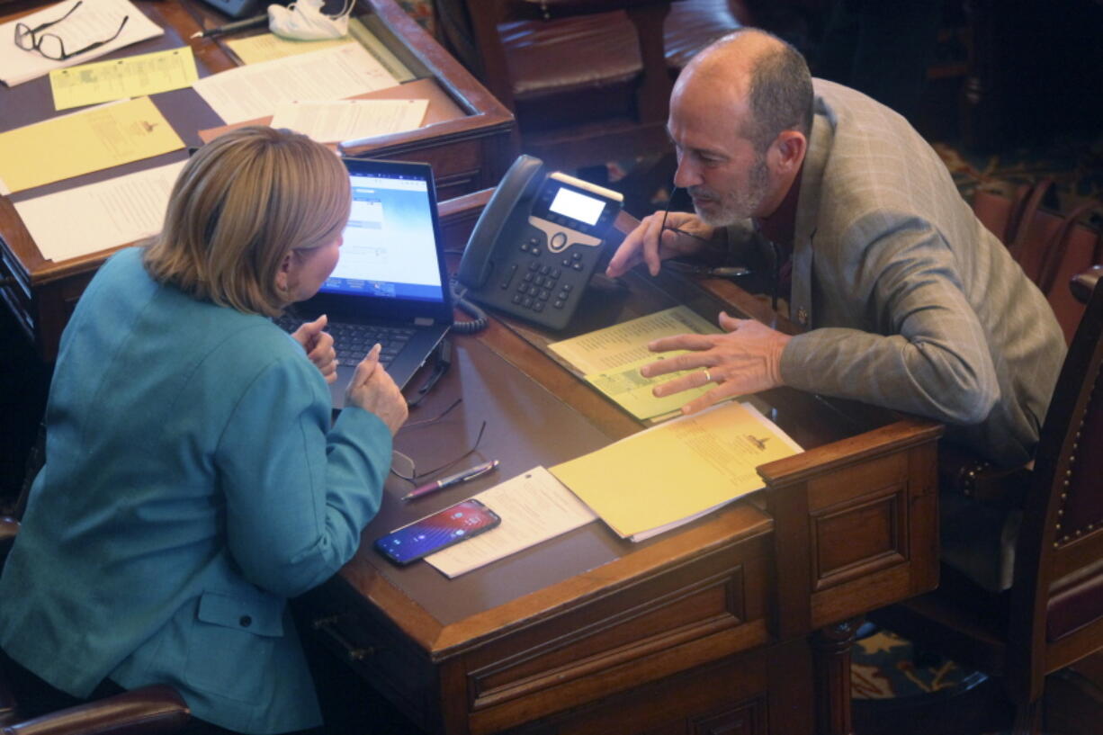 FILE - Kansas state Sens. Caryn Tyson, left, R-Parker, and Mark Steffen, right, R-Hutchinson, confer, at the Statehouse in Topeka, Kan., Feb. 4, 2021. Steffen, also is a physician, said Wednesday, Jan. 26, 2022, he's been under investigation by the state medical board for more than a year over his public comments about COVID-19, dating back even to late 2020, before he was in the Legislature. He also said he's written prescriptions for the parasitic worm treatment ivermectin as a treatment for COVID-19.