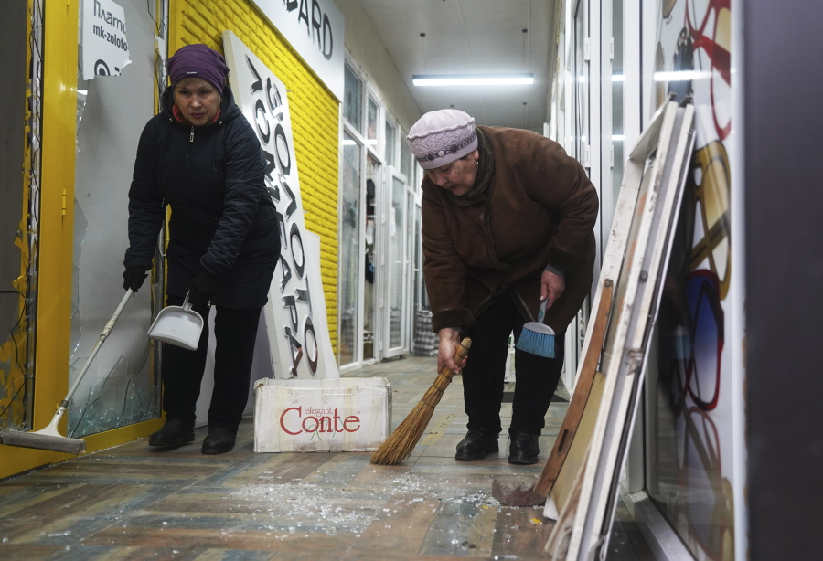 Vendors clean up their store that was broken into and looted during clashes in Almaty, Kazakhstan, Monday, Jan. 10, 2022. Kazakhstan's health ministry says over 150 people have been killed in protests that have rocked the country over the past week. President Kassym-Jomart Tokayev's office said Sunday that order has stabilized in the country and that authorities have regained control of administrative buildings that were occupied by protesters, some of which were set on fire.