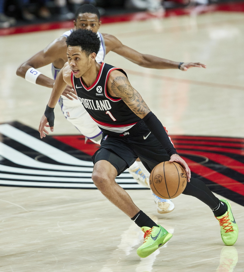 Portland Trail Blazers guard Anfernee Simons (1) drives to the basket in front of Sacramento Kings guard De'Aaron Fox during the second half of an NBA basketball game in Portland, Ore., Sunday, Jan. 9, 2022.