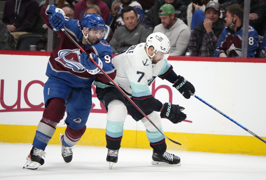 Colorado Avalanche center Nazem Kadri, left, fights for control of the puck with Seattle Kraken right wing Jordan Eberle in the second period of an NHL hockey game Monday, Jan. 10, 2022, in Denver.