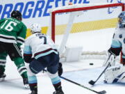 Dallas Stars forward Joe Pavelski (16) scores a goal past Seattle Kraken forward Jordan Eberle (7) and goaltender Philipp Grubauer (31) during the first period of an NHL hockey game, Wednesday, April 12, 2022, in Dallas.