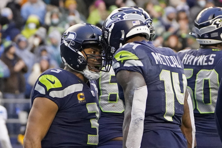 Seattle Seahawks quarterback Russell Wilson, left, reacts with wide receiver DK Metcalf (14) after he passed Metcalf for a touchdown against the Detroit Lions during the second half of an NFL football game, Sunday, Jan. 2, 2022, in Seattle.