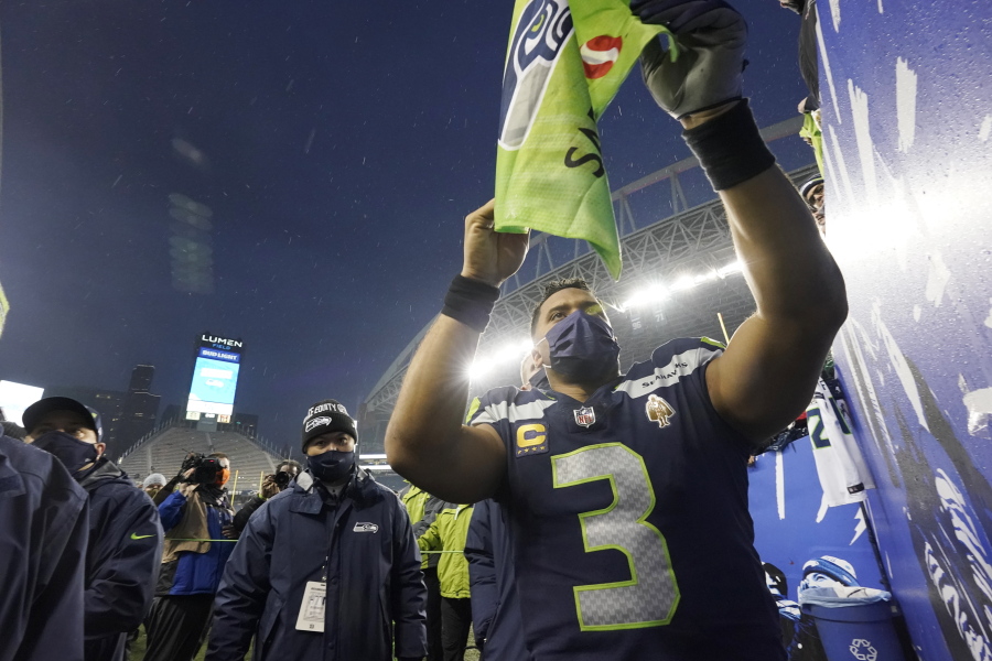 Seattle Seahawks quarterback Russell Wilson gives autographs after a game against the Detroit Lions, Sunday.
