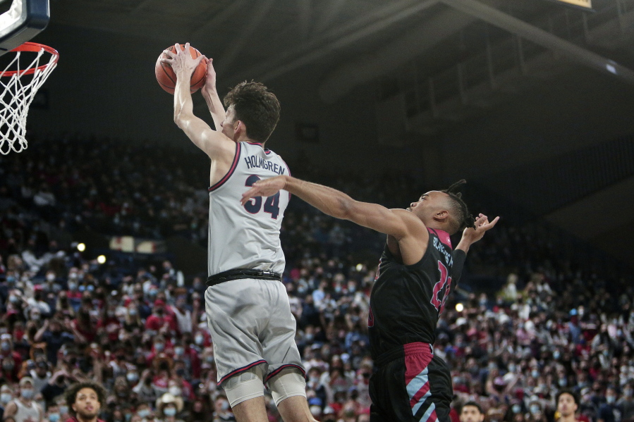 Gonzaga center Chet Holmgren, left, goes up for a dunk in front of Loyola Marymount guard Cam Shelton during the first half of an NCAA college basketball game, Thursday, Jan. 27, 2022, in Spokane, Wash.