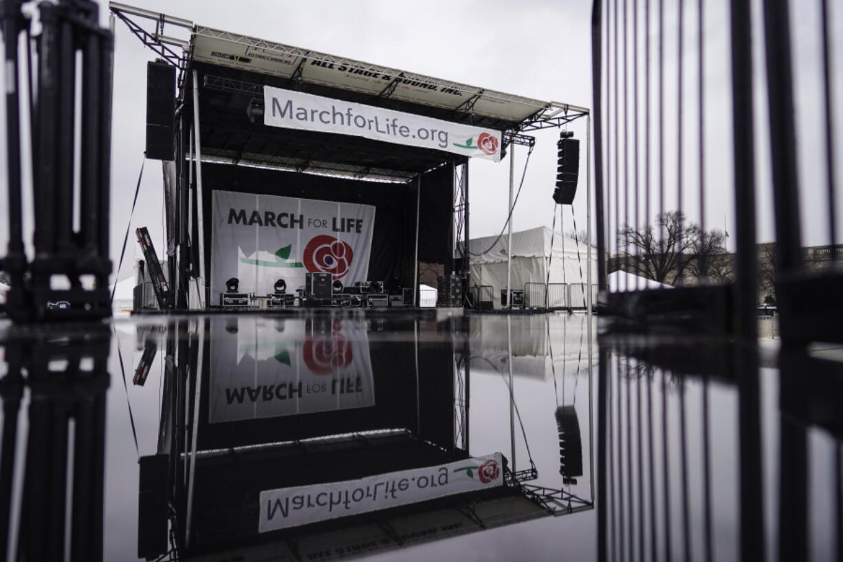 A stage in place for the March for Life rally is reflected on a wet camera stand on the National Mall in Washington, Thursday, Jan. 20, 2022. The March for Life is scheduled to take place Friday, Jan. 21, 2022.