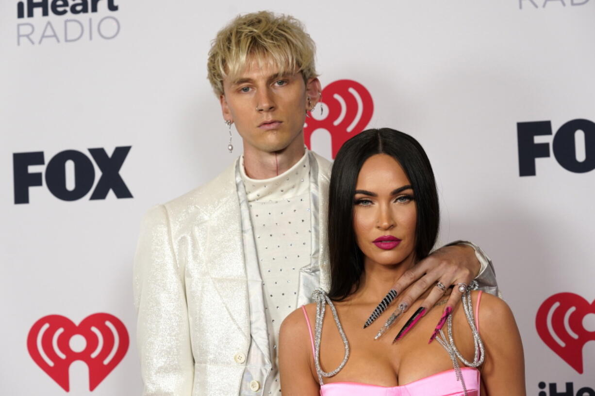 FILE - Megan Fox, right, and Machine Gun Kelly attend the iHeartRadio Music Awards on May 27, 2021, in Los Angeles. Fox and Kelly are engaged. The actor and rapper have decided to legalize their dramatically eccentric coupling, according to Instagram videos that each posted Wednesday, Jan. 12, 2022.