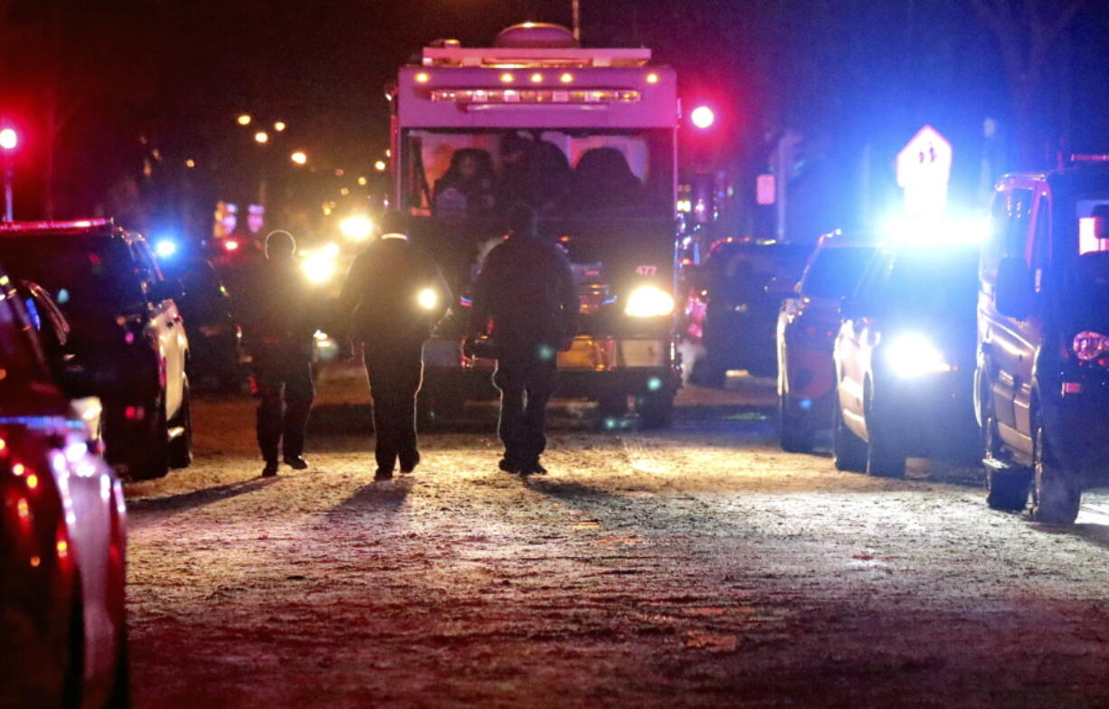 Police investigate the scene where five people were found dead in a Milwaukee, Wisc., home, Sunday, Jan. 23, 2022, in what police are investigating as multiple homicides, authorities said.