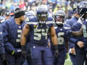 Seattle Seahawks linebacker Bobby Wagner (54) walks off the field with quarterback Russell Wilson (3) and free safety Quandre Diggs (6) after being injured during the first half of an NFL football game against the Detroit Lions, Sunday, Jan. 2, 2022, in Seattle. Wagner suffered a knee injury on Detroit's first play from scrimmage in the game, which the Seahawks won, 51-29.
