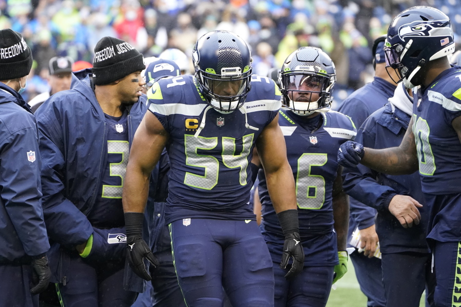 Seattle Seahawks linebacker Bobby Wagner (54) walks off the field with quarterback Russell Wilson (3) and free safety Quandre Diggs (6) after being injured during the first half of an NFL football game against the Detroit Lions, Sunday, Jan. 2, 2022, in Seattle. Wagner suffered a knee injury on Detroit's first play from scrimmage in the game, which the Seahawks won, 51-29.