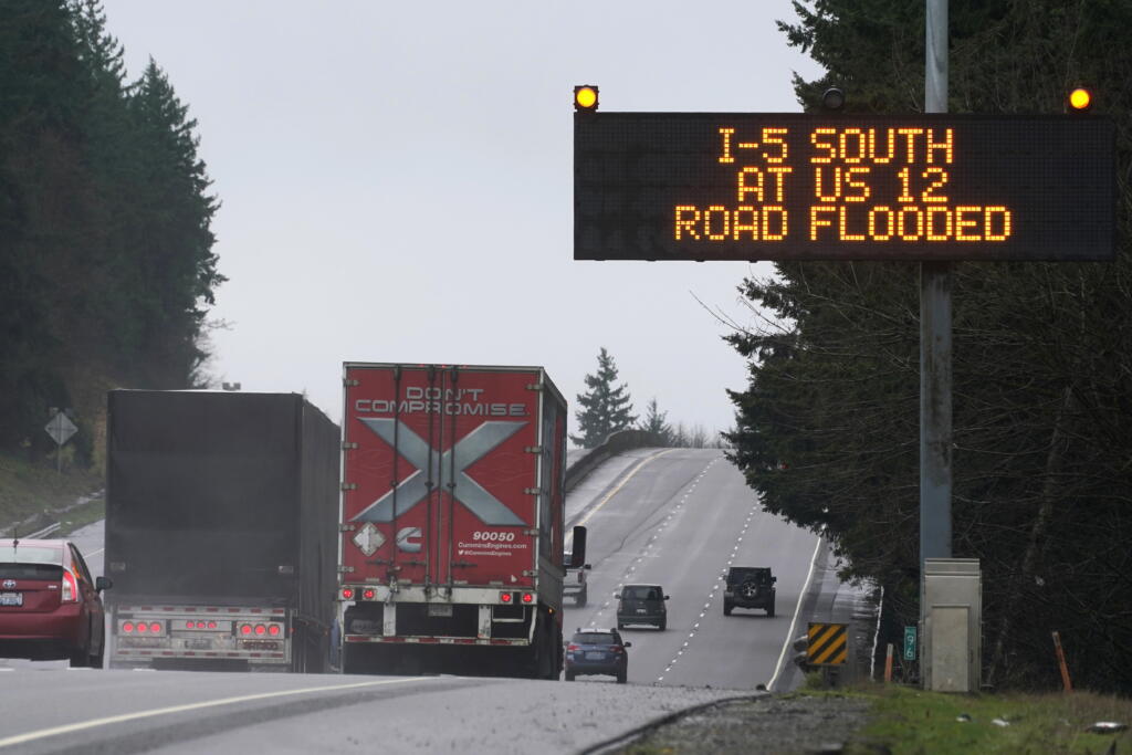 A sign warns drivers of a section of Interstate 5 that is closed ahead due to rising flood water from the Chehalis River, Friday, Jan. 7, 2022, near Rochester, Wash. Rain and snow continued to fall across the Pacific Northwest Friday, causing flooding and concerns about avalanche danger in the mountains. (AP Photo/Ted S.