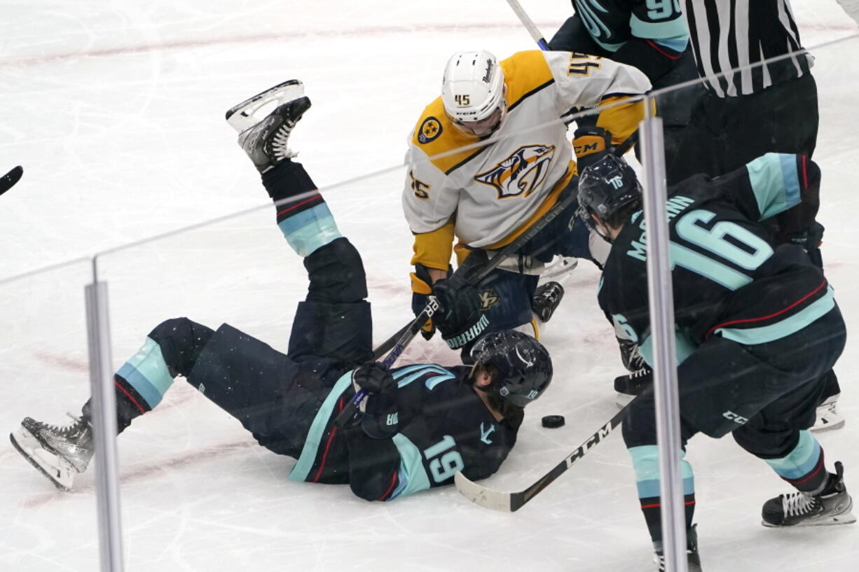 Seattle Kraken's Calle Jarnkrok (19) tumbles in front of Nashville Predators' Alexandre Carrier in the first period of an NHL hockey game Tuesday, Jan. 25, 2022, in Seattle.