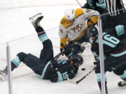 Seattle Kraken's Calle Jarnkrok (19) tumbles in front of Nashville Predators' Alexandre Carrier in the first period of an NHL hockey game Tuesday, Jan. 25, 2022, in Seattle.