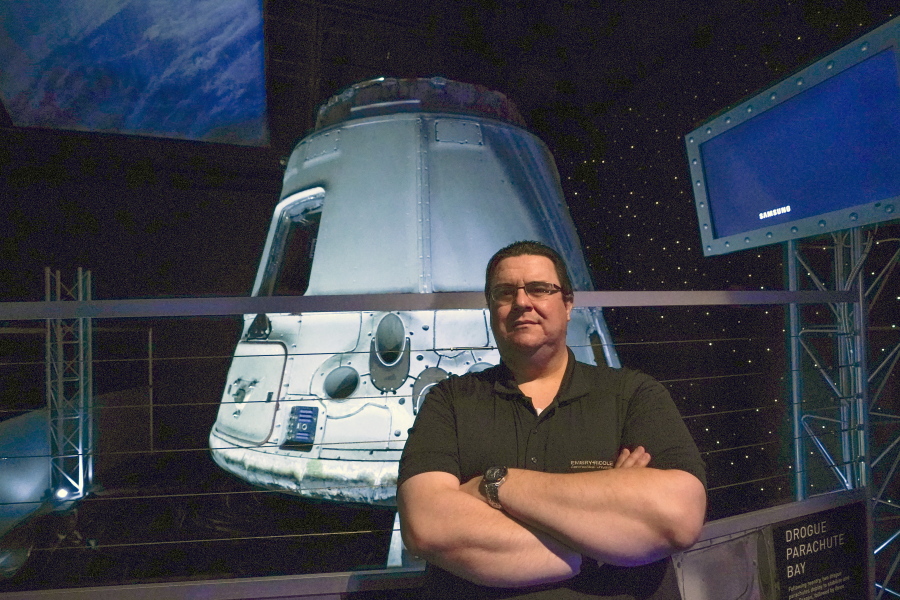 Kyle Hippchen, a Florida-based airline captain, poses for a photo in front of a SpaceX Dragon capsule at the Kennedy Space Center Visitor Complex in Cape Canaveral, Fla., Friday, Jan. 21, 2022. Hippchen, the real winner of a first-of-its-kind sweepstakes, gave his seat on a SpaceX flight to his college roommate. Though his secret is finally out, that doesn't make it any easier knowing he missed his chance to orbit Earth because he exceeded the weight limit.