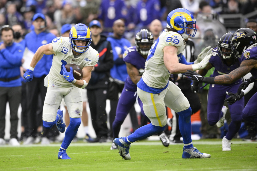 Los Angeles Rams wide receiver Cooper Kupp, left, runs with the ball after making a catch against the Baltimore Ravens during the second half of an NFL football game, Sunday, Jan. 2, 2022, in Baltimore. On the play, Kupp broke the Rams' franchise single season record for most receiving yards after surpassing Isaac Bruce's 1,781 yards set in 1995.