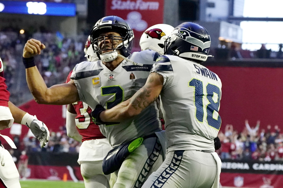 Seattle Seahawks quarterback Russell Wilson, left, celebrates his touchdown run against the Arizona Cardinals with Seattle Seahawks wide receiver Freddie Swain (18) during the second half of an NFL football game Sunday, Jan. 9, 2022, in Glendale, Ariz.