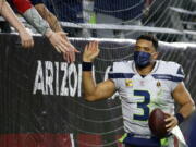Seattle Seahawks quarterback Russell Wilson gets high-fives from fans after the Seahawks defeated the Arizona Cardinals after an NFL football game Sunday, Jan. 9, 2022, in Glendale, Ariz. The Seahawks won 38-30.