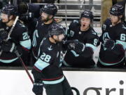 Seattle Kraken's Ryan Donato (9) yells as he congratulates Carson Soucy (28) for scoring against the San Jose Sharks in the second period of an NHL hockey game Thursday, Jan. 20, 2022, in Seattle.