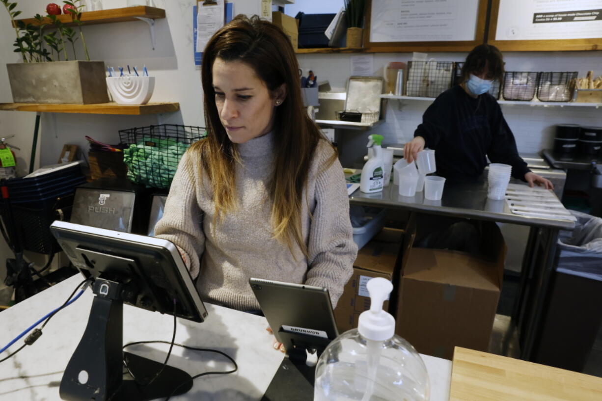 Deena Jalal, owner of plant-based ice cream chain FoMu, works behind the counter in her shop on Tremont Street, Friday, Jan 14, 2022, in Boston.
