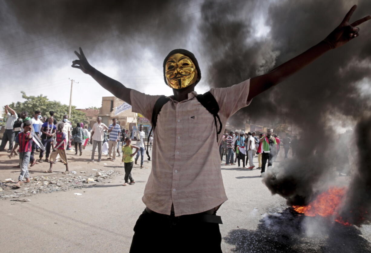 A man flashes the victory sign during a protest to denounce the October 2021 military coup, in Khartoum, Sudan, Sunday, Jan. 9, 2022. The United Nations said Saturday it would hold talks in Sudan to try to get the country's democratic transition back on track after it was derailed by the coup.