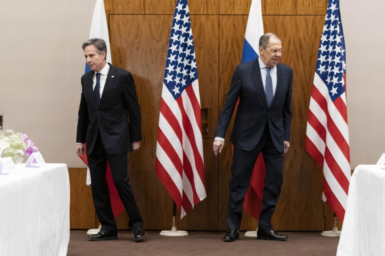 US Secretary of State Antony Blinken, left, and Russian Foreign Minister Sergey Lavrov move to their seats before their meeting, Friday, Jan. 21, 2022, in Geneva, Switzerland.