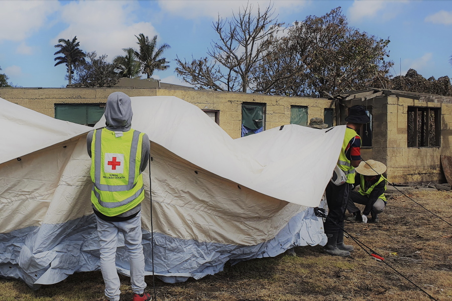 In this photo released by the Tonga Red Cross Society, Red Cross teams set up a temporary shelter in Sopu, Nukualofa, Saturday, Jan. 22, 2022, as the Tonga island group grapples with the aftermath from the recent underwater volcanic eruption.