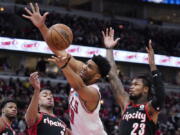 Chicago Bulls center Tony Bradley, center, rebounds a ball against Portland Trail Blazers forward Trendon Watford, front left, and guard Ben McLemore (23) during the second half of an NBA basketball game in Chicago, Sunday, Jan. 30, 2022. (AP Photo/Nam Y.