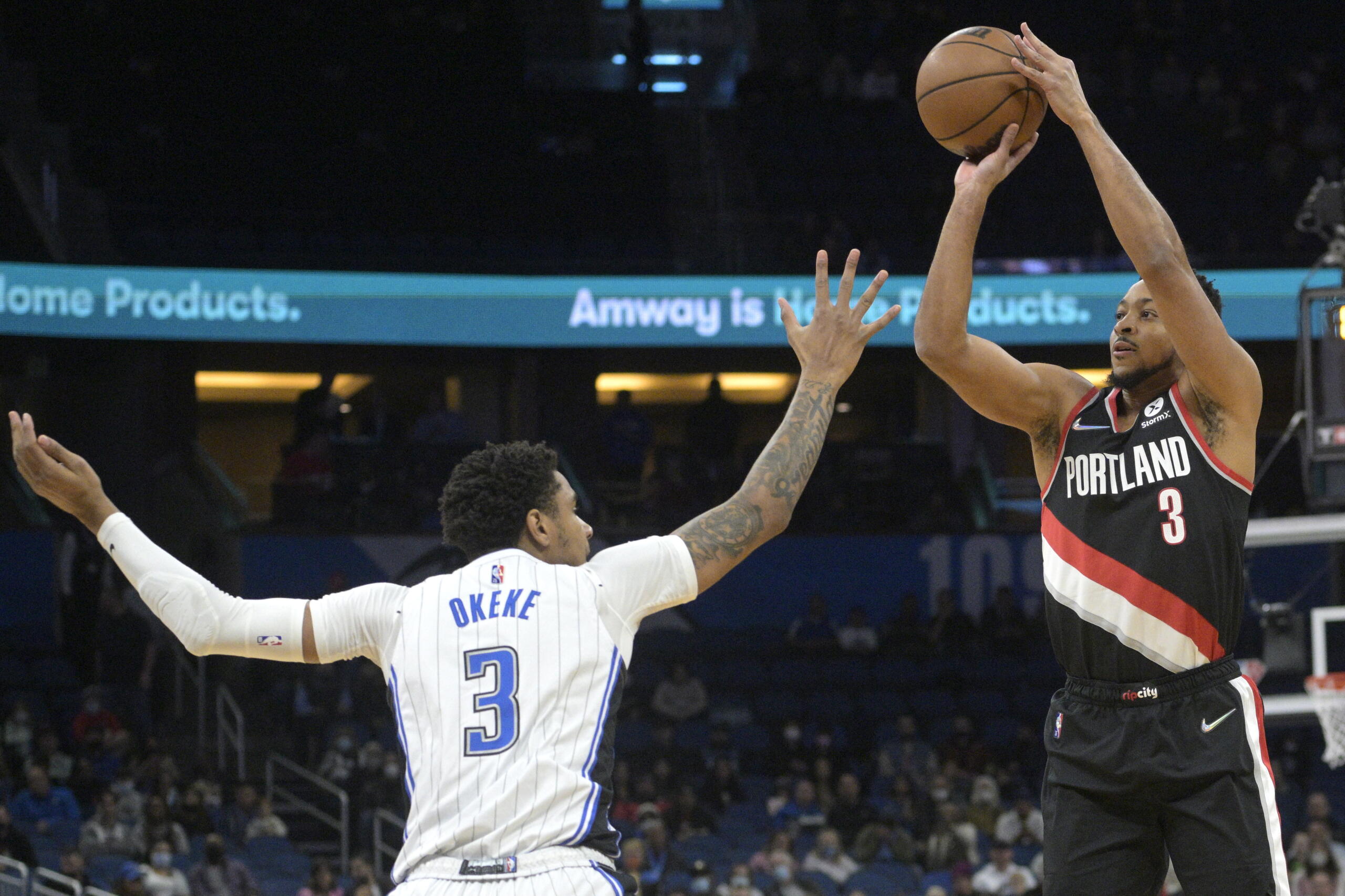 Portland Trail Blazers guard CJ McCollum, right, goes up for a three-point basket in front of Orlando Magic forward Chuma Okeke, left, during the first half of an NBA basketball game, Monday, Jan. 17, 2022, in Orlando, Fla. (AP Photo/Phelan M.