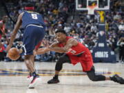 Portland Trail Blazers guard Dennis Smith Jr., right, tries to steal the ball from Denver Nuggets forward Will Barton in the first half of an NBA basketball game Thursday, Jan. 13, 2022, in Denver.