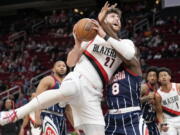 Portland Trail Blazers center Jusuf Nurkic (27) drives to the basket as Houston Rockets forward Jae'Sean Tate (8) defends during the first half of an NBA basketball game, Friday, Jan. 28, 2022, in Houston.