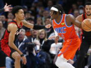 Oklahoma City Thunder guard Luguentz Dort (5) looks to pass the ball around Portland Trail Blazers guard Anfernee Simons, left, in the first half of an NBA basketball game Monday, Jan. 31, 2022, in Oklahoma City.