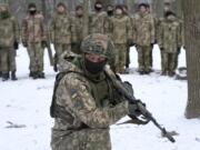 An instructor trains members of Ukraine's Territorial Defense Forces, volunteer military units of the Armed Forces, in a city park in Kyiv, Ukraine, Saturday, Jan. 22, 2022. Dozens of civilians have been joining Ukraine's army reserves in recent weeks amid fears about Russian invasion.