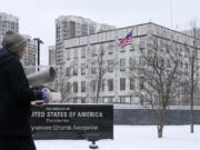 A woman walks past the U.S. Embassy in Kyiv, Ukraine, Monday, Jan. 24, 2022. The State Department is ordering the families of all American personnel at the U.S. Embassy in Kyiv to leave the country and allowing non-essential staff to leave Ukraine. The move comes amid heightened fears of a Russian invasion of Ukraine despite talks between U.S. and Russian officials.