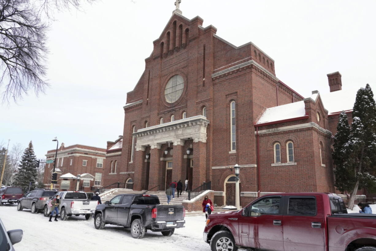 Church of the Incarnation is shown, Sunday, Jan. 23, 2022, in Minneapolis, where residents could pick up coats, sweaters and frozen chicken. With attendance dwindling, historic urban churches built in the early to mid-20th century, are fulfilling their faith-based mission to serve their neighbors. Between mass, people can pick up coats and sweaters along with bags of frozen chicken.