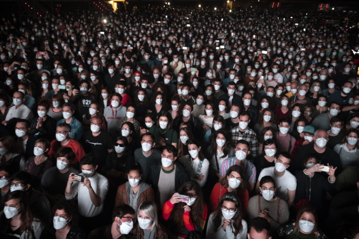 FILE - People using face masks attend a music concert in Barcelona, Spain, March 27, 2021. With one of Europe's highest vaccination rates and its most pandemic-battered economies, the Spanish government is laying the groundwork to approach the virus in much the same way countries deal with flu or measles.