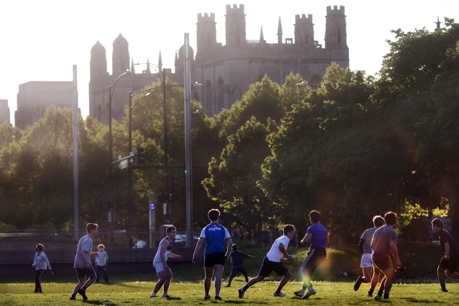 FILE - University of Chicago men's rugby team players practice on the Midway Plaisance near the campus in Chicago, May 6, 2021. The University of Chicago is delaying its new term and holding the first two weeks online.