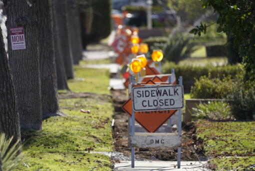 A sidewalk is closed as crews work on repairs Monday in Upland, Calif. After a loss in revenue in the early months of the pandemic, city officials say Upland is now doing well financially, boosted partly by federal pandemic aid. The city plans to use part of that aid to repave parking lots and repair hundreds of sections of sidewalks.