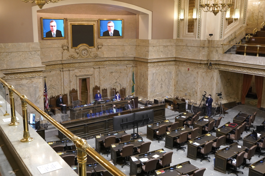 FILE - House Republican Leader J.T. Wilcox, R-Yelm, is displayed on video screens as he speaks remotely following opening remarks from House Speaker Laurie Jinkins, D-Tacoma, during the opening session of the Washington state House, Jan. 10, 2022, at the Capitol in Olympia, Wash. As lawmakers in some Democratic-led states meet remotely because of renewed COVID-19 concerns, their counterparts in many Republican-led legislatures are beginning their 2022 sessions with an aggressive push to outlaw vaccine requirements in workplaces and schools and roll back the government's power to mandate pandemic precautions. (AP Photo/Ted S.