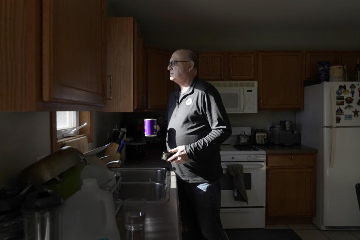 Roger Strukhoff 67, looks out his kitchen window after making a cup of coffee Thursday in his DeKalb, Ill., home. Strukhoff was being treated for intestinal bleeding at a hospital outside Chicago this month when he suffered a mild heart attack.